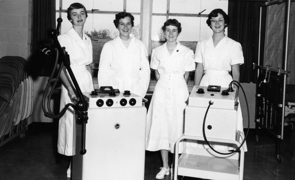 Physical therapy students pose with electrotherapy equipment, 1957